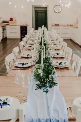a long long table with white chairs and candles at Homutův statek in Kokořín