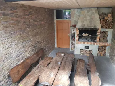 a room with wooden benches in front of a fireplace at Penzion Hudebka in Louny