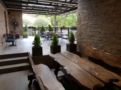 a patio with a wooden table and potted plants at Penzion Hudebka in Louny