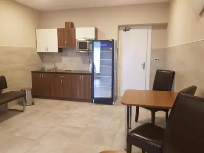 a kitchen with a refrigerator and a table and chairs at Penzion Hudebka in Louny