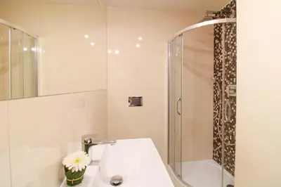 a white bathroom with a sink and a shower at Bouquet Apartments in Prague