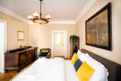 a bedroom with a bed and a desk and a painting at Luxurious Kafka family apt in Old Town in Prague