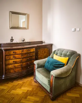 a living room with a chair and a dresser at Luxurious Kafka family apt in Old Town in Prague