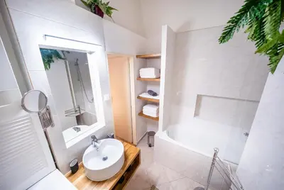 a white bathroom with a sink and a tub at Luxurious Kafka family apt in Old Town in Prague