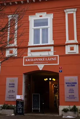 a red building with a sign that reads kalamoslezlezlezlez k at Penzion Královské lázně in Poděbrady