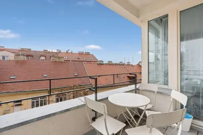 a balcony with a table and chairs and a view at The Dante Prague - Family Apartments with FREE PARKING in Prague