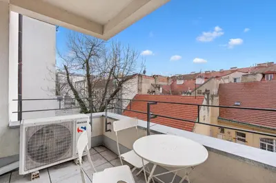 a balcony with a table and chairs on a building at The Dante Prague - Family Apartments with FREE PARKING in Prague