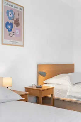 a bedroom with a bed and a table with a lamp at The Dante Prague - Family Apartments with FREE PARKING in Prague