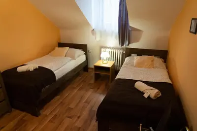 a bedroom with two beds and a window at Hotel U Beránků in Libochovice