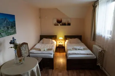 a room with two beds and a table in it at Hotel U Beránků in Libochovice