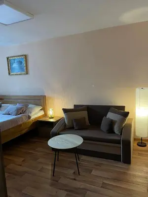 a living room with a couch and a bed at Hotel U Beránků in Libochovice