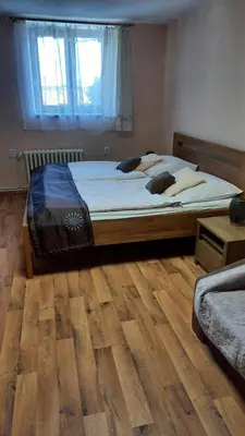 a bedroom with a bed and a wooden floor at Hotel U Beránků in Libochovice