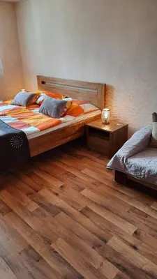 a bedroom with a large bed and a wooden floor at Hotel U Beránků in Libochovice