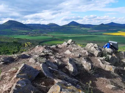 a person sitting on top of a rocky mountain at Apartmán Třebenice - vstupní brána do Českého středohoří in Třebenice