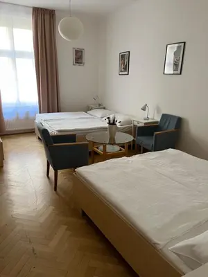 a hotel room with two beds and a table and chairs at Residence u Vejvodů in Prague