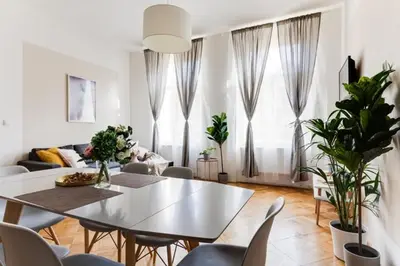 a white living room with a table and chairs at New & cozy 3Bds in Historical Center - S8 in Prague