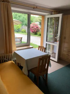 a table and chairs in a room with a window at Apartment Trojska in Prague