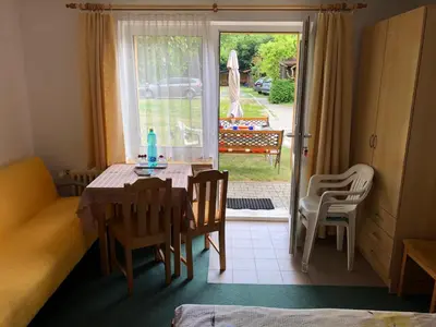 a dining room with a table and chairs and a window at Apartment Trojska in Prague