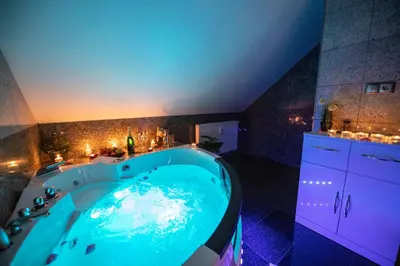 a large blue tub in a bathroom with lights at VIP suite hotel Heinz in Dobříš