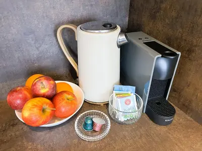 a coffee maker and some apples and oranges on a counter at Apt 100 Prague in Prague