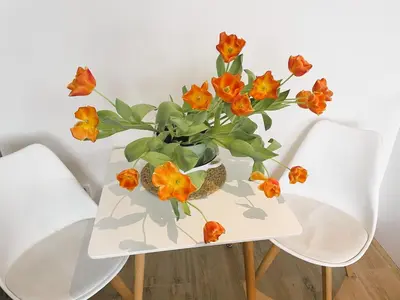a vase of orange flowers sitting on a table at Apt 100 Prague in Prague