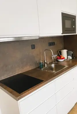 a kitchen with white cabinets and a sink at Apt 100 Prague in Prague