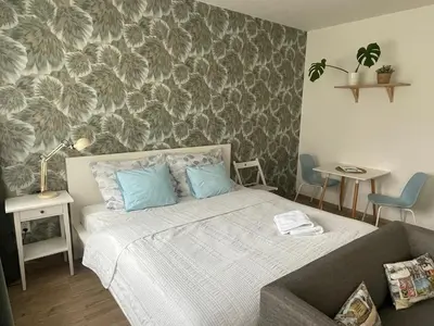a bedroom with a bed with blue pillows and a couch at Apt 100 Prague in Prague