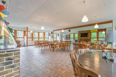 a dining room with wooden tables and chairs at Kemp Andělská laguna Slapy in Nalžovice