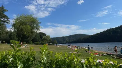 a group of people on the beach at a lake at Kemp Andělská laguna Slapy in Nalžovice