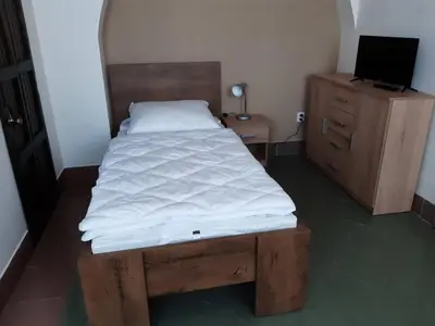 a bedroom with a bed and a desk with a computer at Penzion Cerhenice in Cerhenice