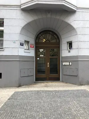 a building with a brown door and a brick sidewalk at Apartment Slavikova 11 in Prague