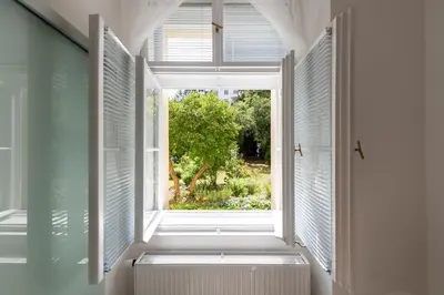 an open window with a radiator in a room with a tree at Apartment Slavikova 11 in Prague