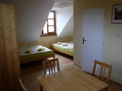 a room with two beds and a table and a window at Farma Zahradnice in Olbramovice Ves