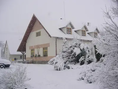 a house covered in snow in a yard at Farma Zahradnice in Olbramovice Ves