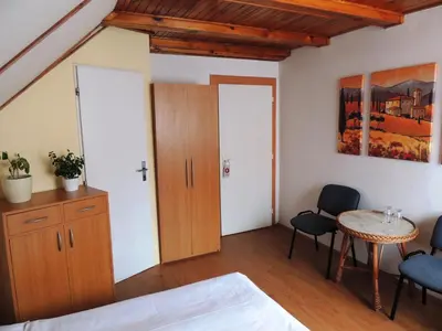 a bedroom with a bed and a table and chairs at Penzion Pohoda Beroun in Beroun
