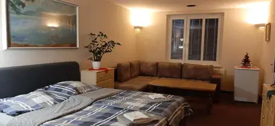 a living room with a bed and a couch at Penzion Pohoda Beroun in Beroun