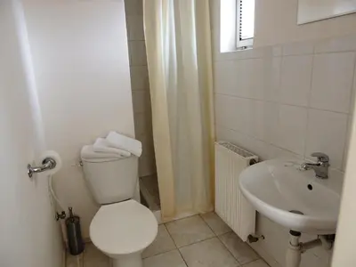 a white bathroom with a toilet and a sink at Penzion Pohoda Beroun in Beroun