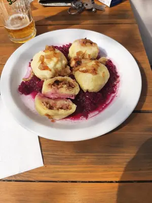 a white plate of food on a wooden table at Penzion Pohoda Beroun in Beroun