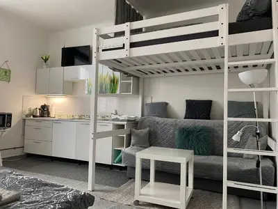 a living room with a bunk bed and a kitchen at Tulip Apartment in Prague
