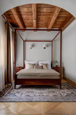 a bedroom with a canopy bed with a rug at Hotel Nerudova 211 in Prague