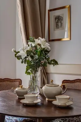 a table with a vase of white flowers and tea sets at Hotel Nerudova 211 in Prague