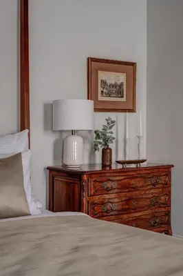 a bedroom with a bed and a dresser with a lamp at Hotel Nerudova 211 in Prague