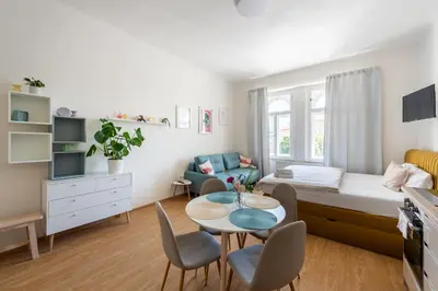a small room with a bed and a table and chairs at Tesnov Residence Apartments in Prague