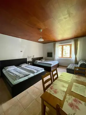 a room with three beds and a table at Šafářův statek Milovice in Milovice