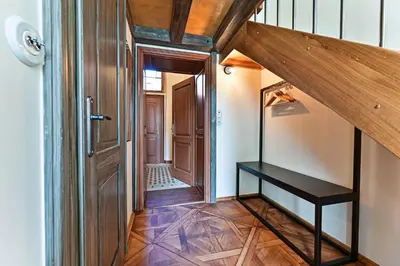 a hallway with a wooden door and a stair case at Apartment Nebovidy II - Air Conditioning - Historic City Center in Prague