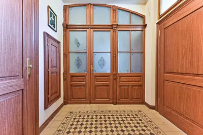a large wooden door in a hallway with a tile floor at Apartment Nebovidy II - Air Conditioning - Historic City Center in Prague