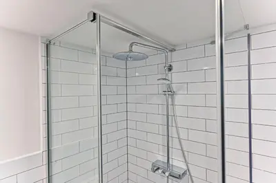 a shower with a glass door in a bathroom at Apartment Nebovidy II - Air Conditioning - Historic City Center in Prague