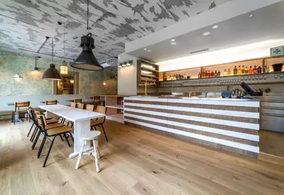 a restaurant with a counter and a table and chairs at Boutique hotel Corso in Řevnice