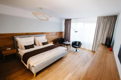 a bedroom with a bed and a desk and a window at Boutique hotel Corso in Řevnice