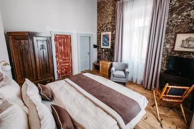 a bedroom with a large bed and a television at Boutique hotel Corso in Řevnice